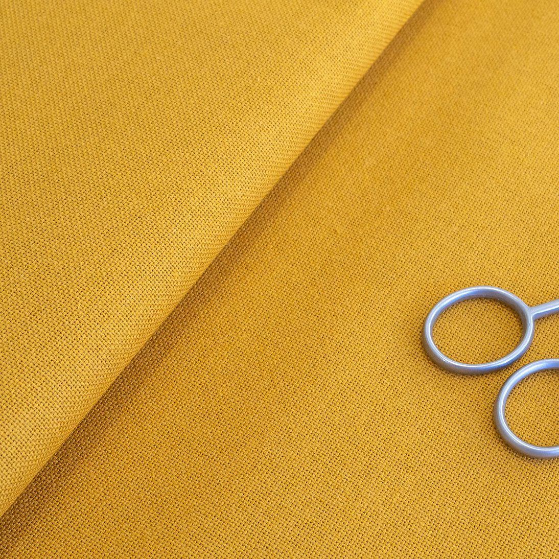 Detalle de la textura de la tela Lugana Murano 32 ct amarillo oscuro de ZWEIGART