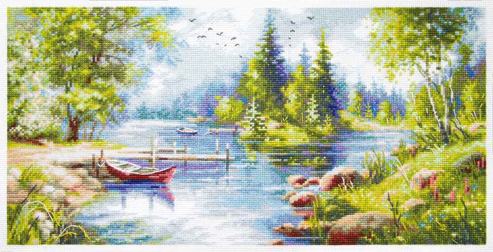 Kit de punto de cruz Magic Needle 70-61 A Day in Calm con paisaje de lago, barca roja, árboles y bosque reflejados en el agua.