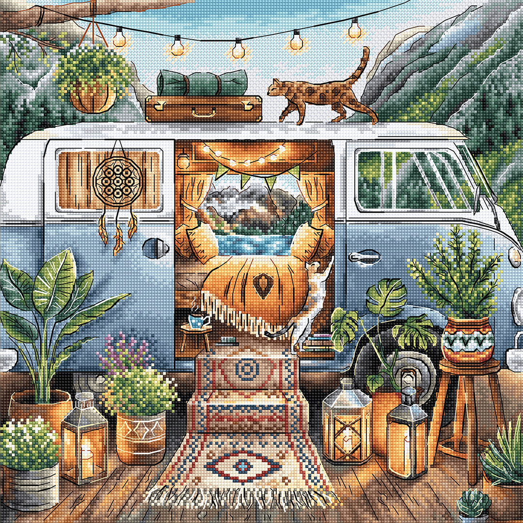 Kit de punto de cruz AVA P017 El Hogar es Donde Aparcamos con una furgoneta camper estilo boho, dos gatos, plantas tropicales, luces decorativas y montañas al fondo.
