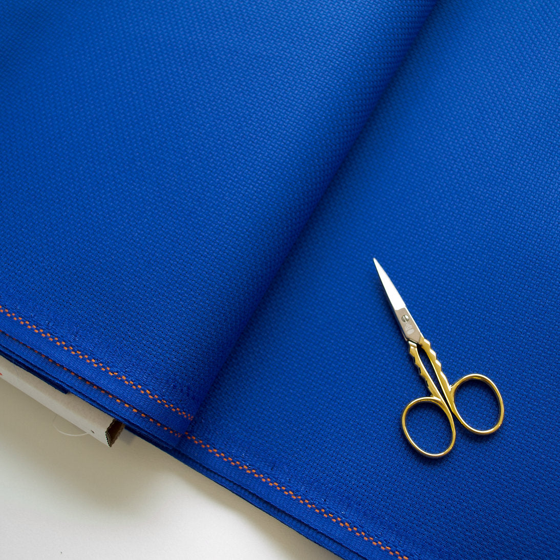 Detalle de la trama uniforme de la tela Aida 14 ct azul de Zweigart