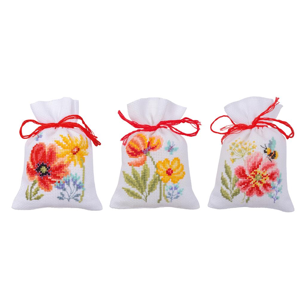 Kit de punto de cruz Vervaco Poppies and Wildflowers con tres bolsitas bordadas con amapolas, flores silvestres y lazo rojo.