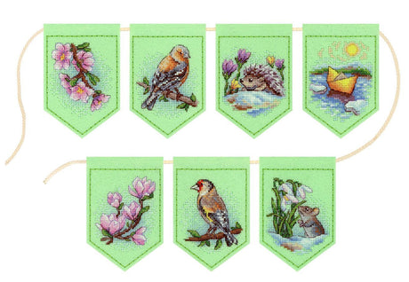Guirnalda de banderines bordados en punto de cruz con flores y pájaros sobre fieltro verde claro estilo primaveral