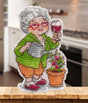 Kit de punto de cruz Oven S1729 Magnet Joy in the Little Things con señora mayor regando una planta, copa en la mano y diseño de imán sobre canvas plástico.