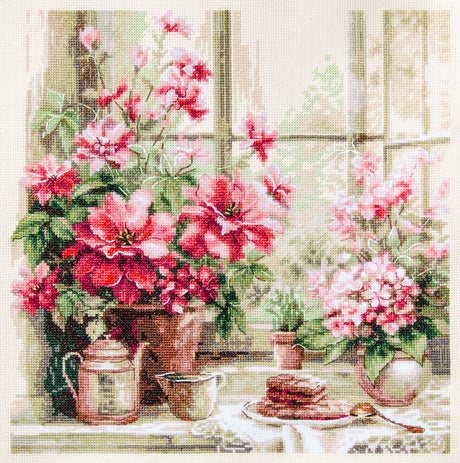Kit de punto de cruz Magic Needle 70-34 Morning in Rosy Tones con flores rosas y rojas junto a una ventana, taza y detalles de mesa sobre Aida marfil.