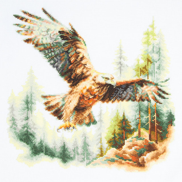 Kit de punto de cruz Magic Needle 70-48 Above the World con águila volando sobre un paisaje de bosque y pinos, bordado en Aida Zweigart blanco antiguo.