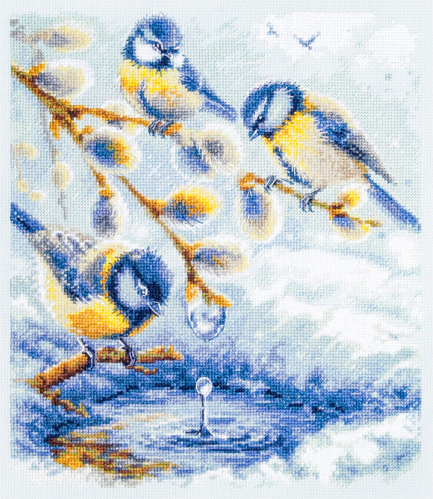 Kit de punto de cruz Magic Needle 70-55 The Promise of Spring con tres pájaros azules y amarillos sobre ramas, gotas de agua y fondo azul hielo.