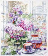 Kit de punto de cruz Magic Needle 70-56 My Serene Morning con flores rosas y lilas, taza de té, tetera y ventana sobre Aida blanca.