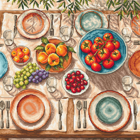 Kit de punto de cruz AVA Stitch P139 Mediterranean Table con mesa mediterránea, platos, copas, tomates, naranjas, uvas y cerezas bordados sobre Aida blanca.