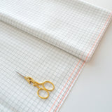 Tela Zweigart Lugana 25 ct Grid 3508/1219 doblada con tijeras de bordado