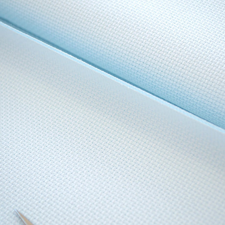 Detalle de la trama uniforme de la tela Aida 14 ct azul claro de Zweigart
