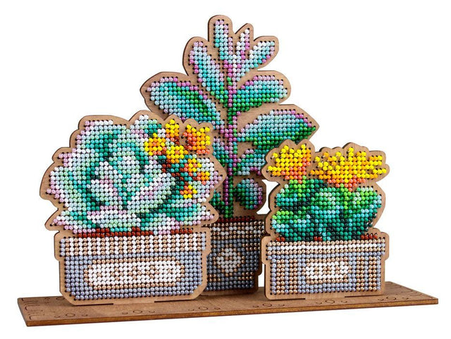 Decoración bordada con abalorios sobre base de madera en forma de jardín de suculentas en 3D con colores verdes y detalles florales