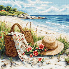 Kit de punto de cruz Luca-S B732 Echo of Summer con paisaje de playa, sombrero, cesta, flores y mar al fondo bordado sobre Aida Zweigart.