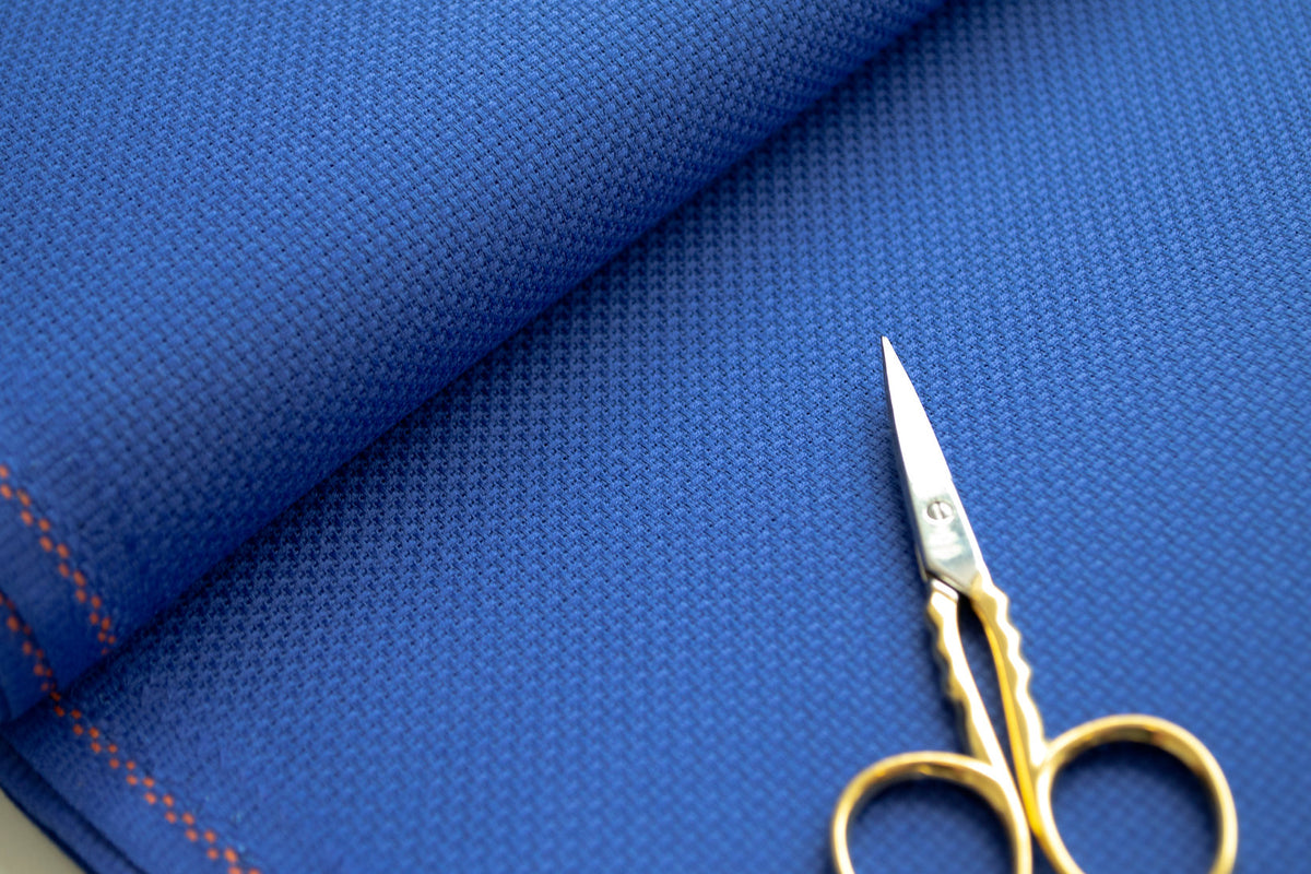 Detalle de la trama uniforme de la tela Aida 14 ct azul de Zweigart