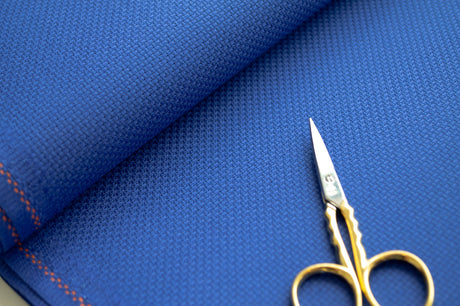 Detalle de la trama uniforme de la tela Aida 14 ct azul de Zweigart