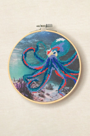 Kit de punto de cruz DMC Pulpo de Joanna Hateley con pulpo azul y rosa sobre fondo marino preimpreso